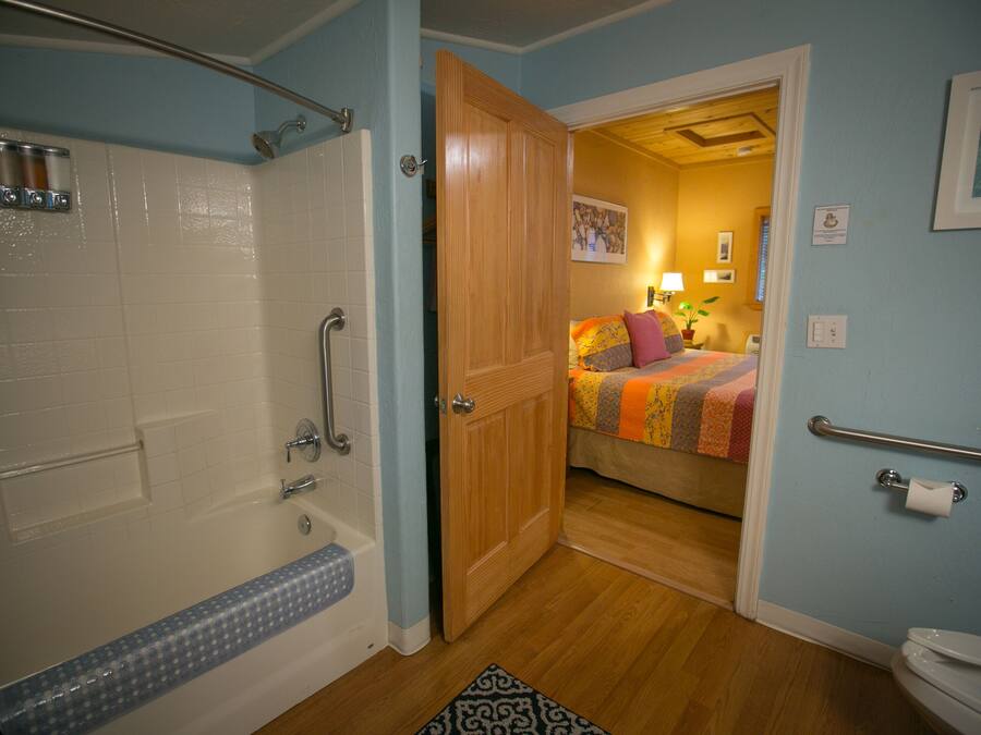 A bathroom with a bathtub, shower, and toilet.