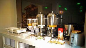 A breakfast bar with coffee makers, a toaster, and various breakfast items.
