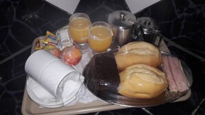 A breakfast tray with bread, ham, juice, and a roll of toilet paper. - Plaza Motel - Adults Only (Votorantim)
