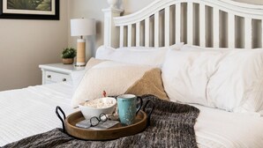 A neatly made bed with a tray of snacks, a mug, and glasses on a wooden tray. - Newly Renovated Sparkling Springs by J and Amy BL990802 (Mesquite)