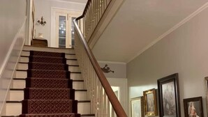 A staircase with a patterned carpet and wooden balusters. - Willard Richards Inn (Nauvoo)