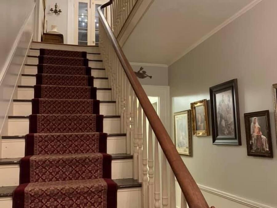 A staircase with a patterned carpet and wooden balusters.