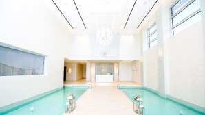 Hotellin aula, jossa on vastaanottotiski, suuri kattokruunu ja allasalue.