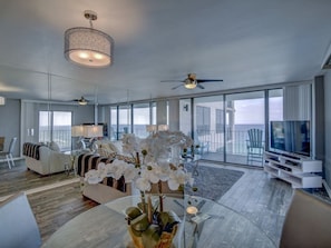 Ein geräumiger Wohnbereich mit großem Fenster, Deckenventilator und modernem TV-Möbel.
