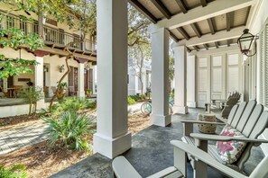 Relax in a serene garden setting with a traditional-style seating area featuring a bench and chairs with floral cushions.