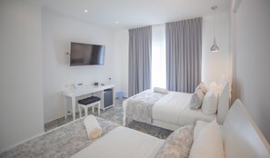 Habitación doble, 2 camas de matrimonio | Minibar, caja fuerte, escritorio y espacio para trabajar con un portátil