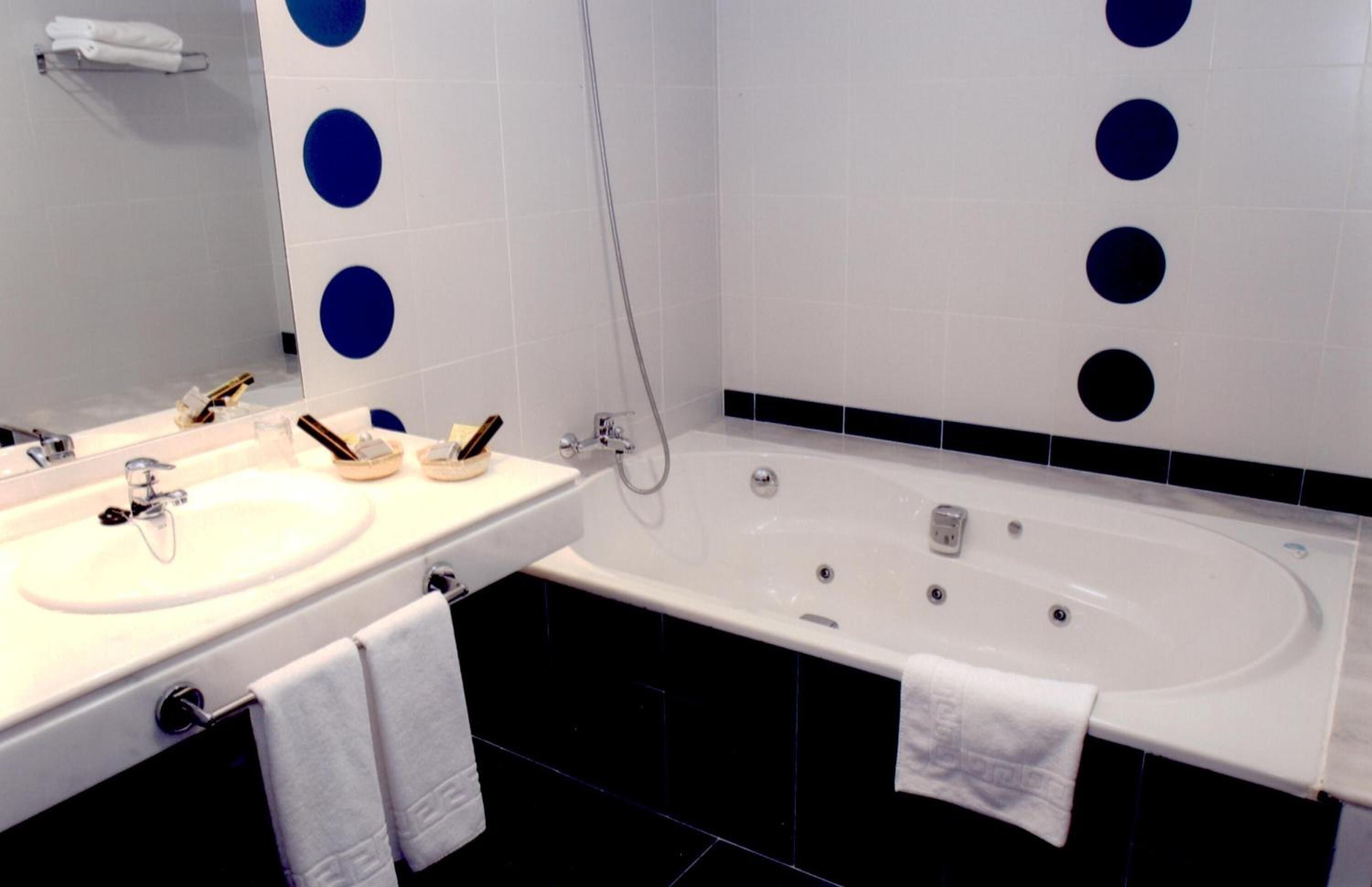A modern bathroom with two sinks, a bathtub, and a shower.