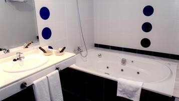 Un baño moderno con dos lavamanos, una bañera y una ducha.