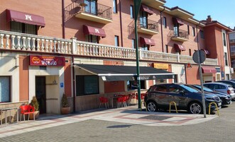 A building with multiple balconies, a restaurant named "La Torta de Tolo" with outdoor seating, and a cafe called "Trepalio".