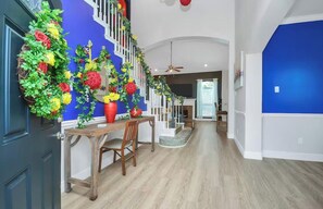 A hallway with a staircase, a dining area with a table and chairs, and a blue wall. - Centrally located Luxury Home Big Backyard 800 Mbps WiFi 10 Med Center Top golf (Houston)
