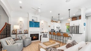 A modern living room with grey sofas, a white armchair, and a coffee table. A fireplace is visible in the background. - Bleeker Cottage - SOUTH OF 30A, FREE GYM/TENNIS, PRIVATE POOL (Rosemary Beach)