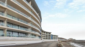 A multi-story hotel with a curved facade, balconies, and a beach view. - 2 bedroom accommodation in Westward Ho! (Westward Ho!)