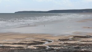 A beach with rocky foreground and calm sea, distant hills, and a clear sky. - 2 bedroom accommodation in Westward Ho! (Westward Ho!)