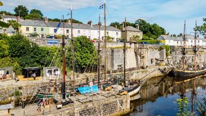 A harbor with a historic ship docked, buildings in the background, and a small dockside café. - A thoughtfully converted three-bedroom barn conversion, near wonderful beaches. (Chacewater)