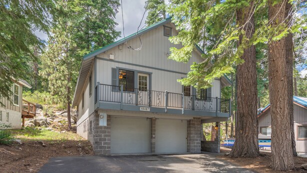 Une maison à deux étages avec un balcon, un garage et une allée.