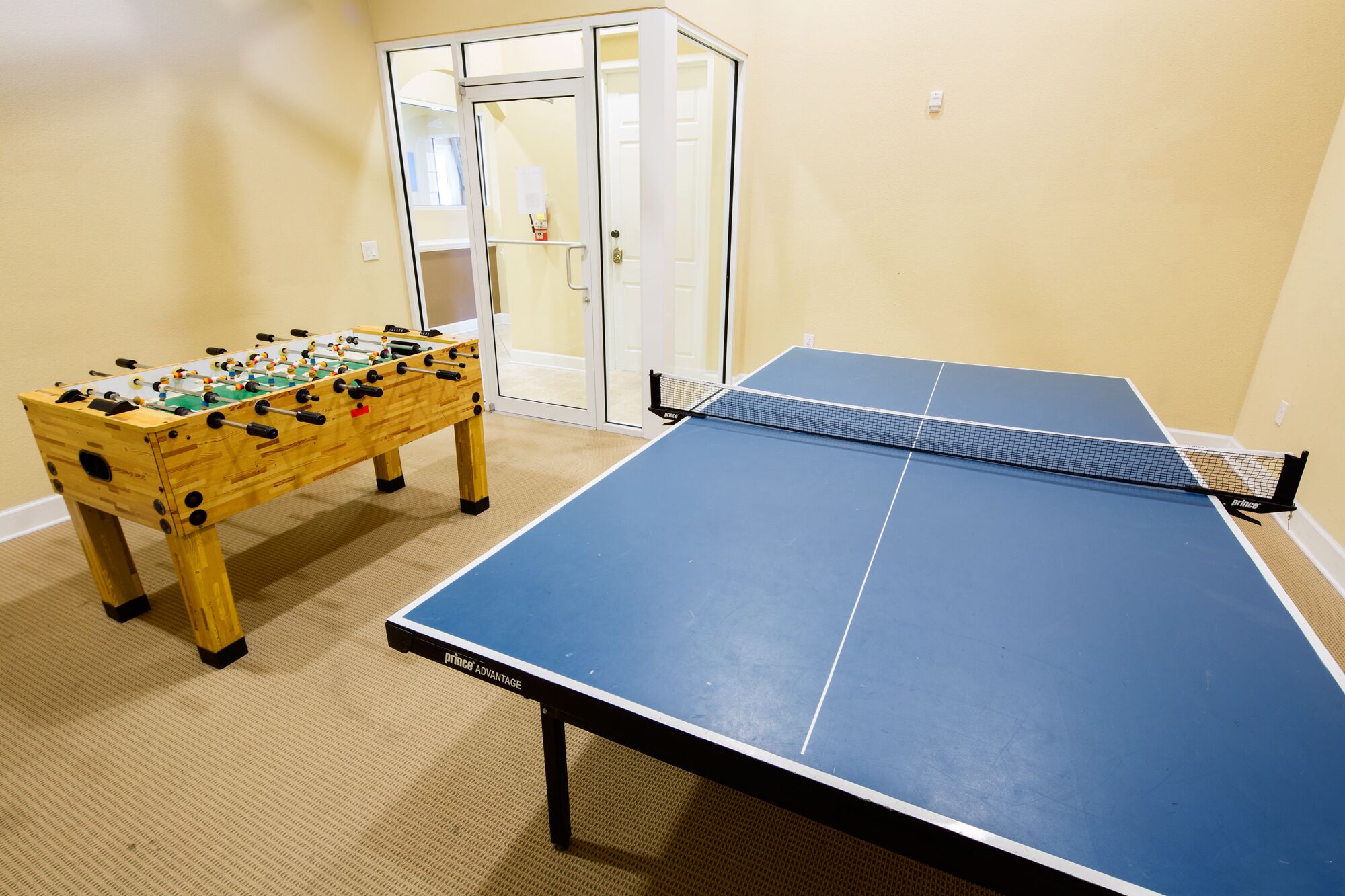 Une pièce équipée d’un baby-foot et d’une table de ping-pong.