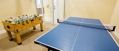 Une pièce équipée d’un baby-foot et d’une table de ping-pong.