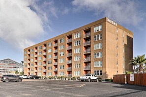 Un hôtel à plusieurs étages, doté d’une façade en briques, de nombreux balcons et d’un parking situé à l’avant.