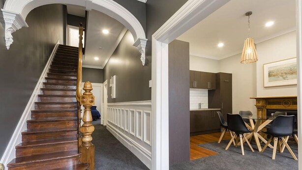 Un escalier avec une rampe en bois menant à un palier.