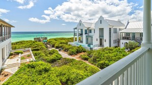 A coastal property with a pool, lush greenery, and a view of the ocean. - Knoepp Cottage & Carriage House - Spectacular Gulf Views, South of 30A (Rosemary Beach)