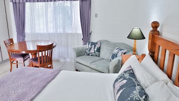 Une chambre d’hôtel avec un lit, un canapé, une table et des chaises.