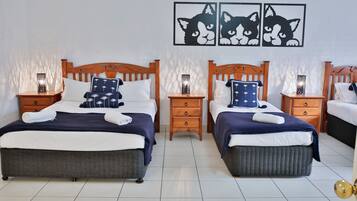 Habitación de hotel con dos camas, cabeceros de madera y mesitas de noche con lámparas.