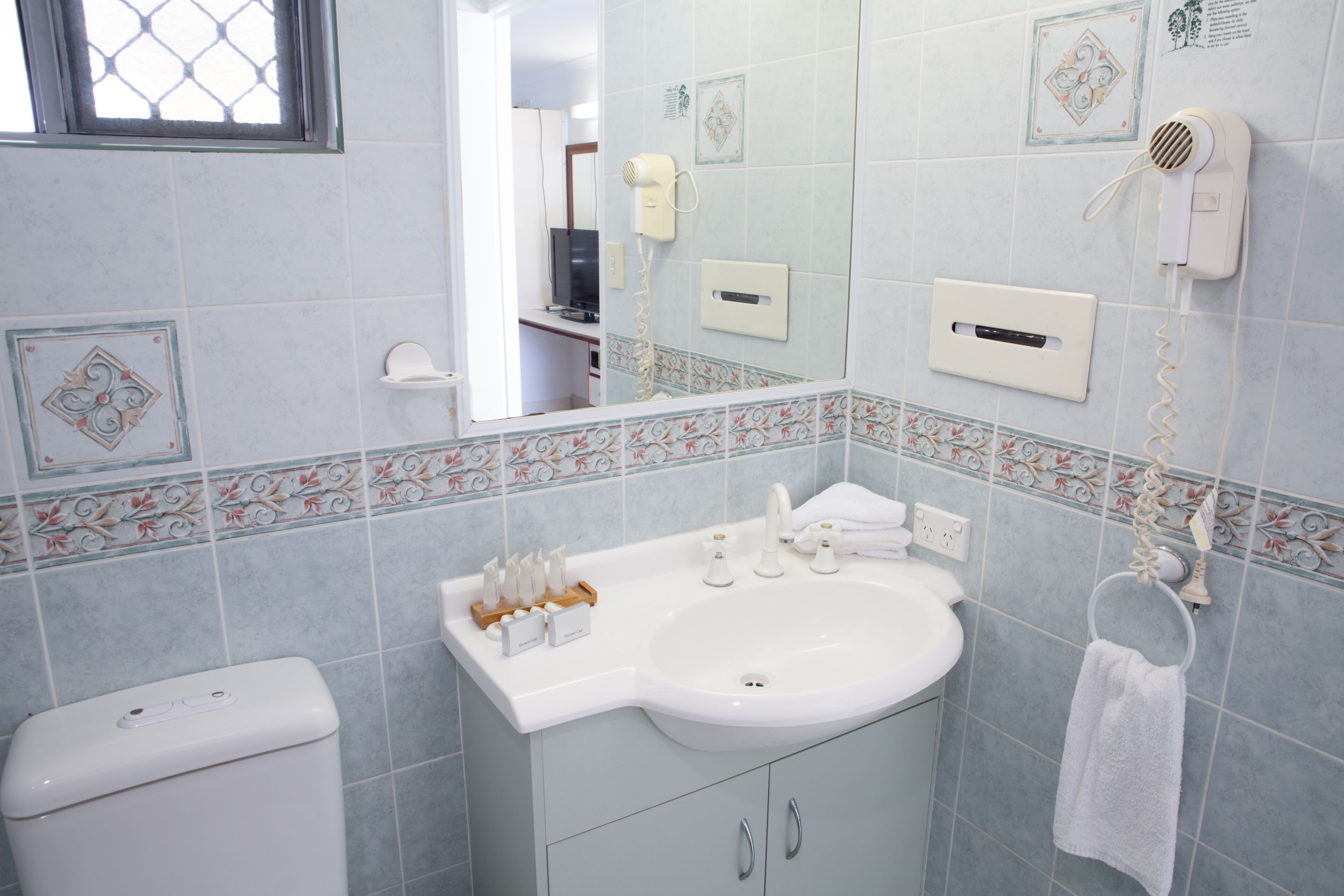 A bathroom with a sink, toilet, and a towel rack.