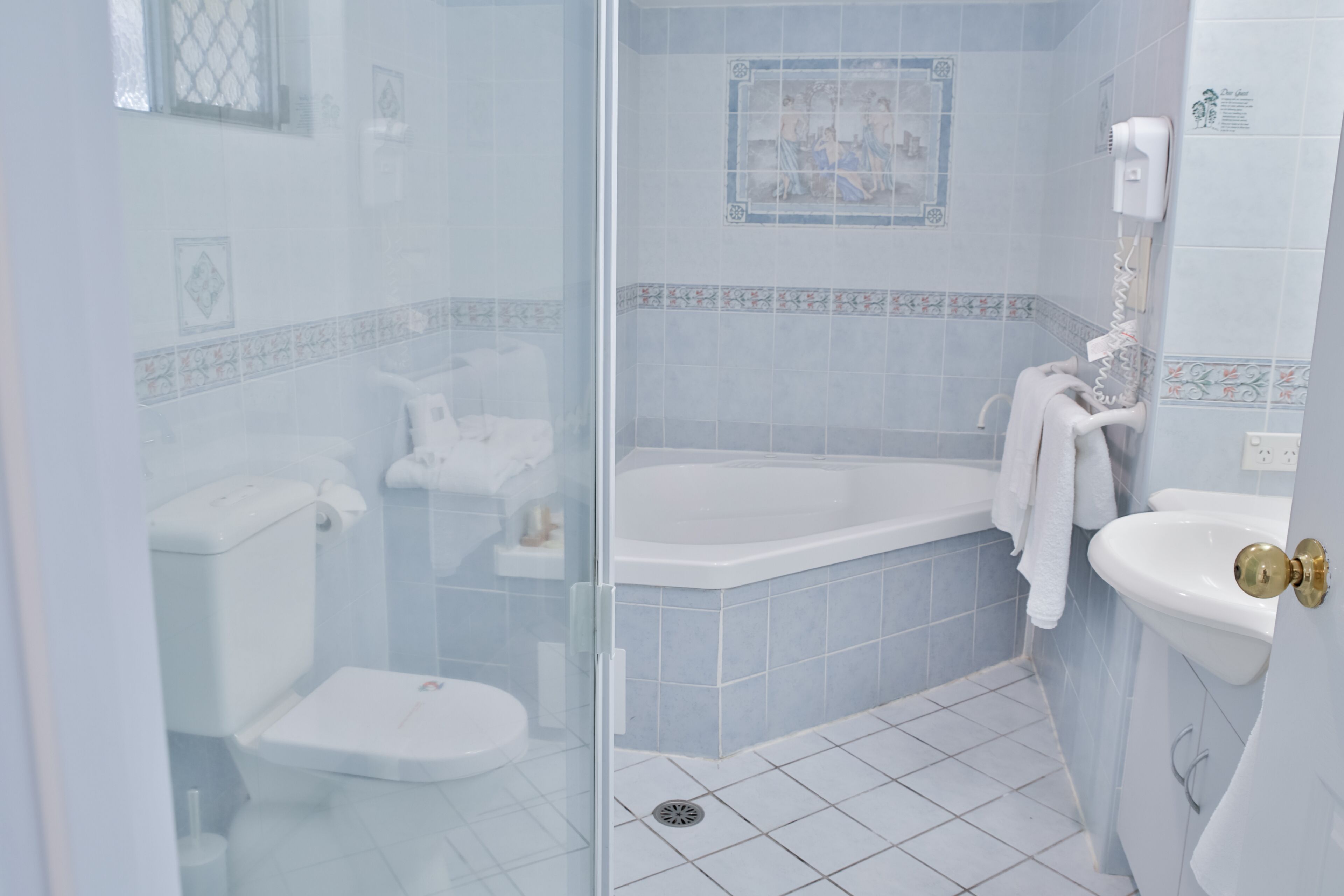 Un baño con cabina de ducha de vidrio, bañera, inodoro y lavamanos.