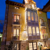 A multi-story building with balconies, large windows, and decorative architectural details.