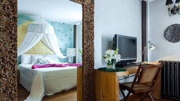 Un dormitorio con cama, mesita de noche, lámpara y un escritorio con silla.