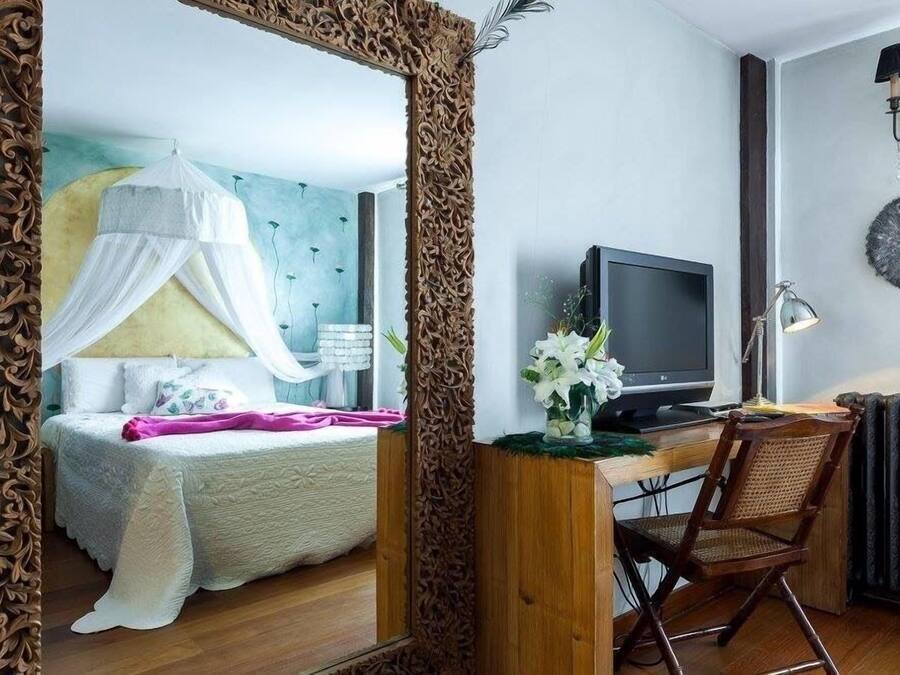 Un dormitorio con cama, mesita de noche, lámpara y un escritorio con silla.