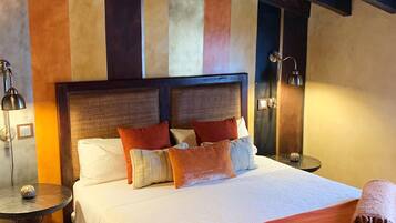 A hotel room with a large bed, two bedside tables, and a headboard.