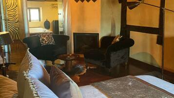 Una habitación acogedora con sofá, chimenea y araña.