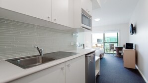 A modern kitchen with a stainless steel sink, white cabinets, and a tiled backsplash. - Pacific Blue  245-265 Sandy Point Rd - Dual Key Access, air conditioned unit with resort facilities and linen supplied (Salamander Bay)