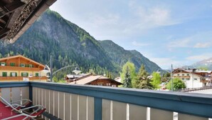 Een balkon met uitzicht op een berg en een dorp.