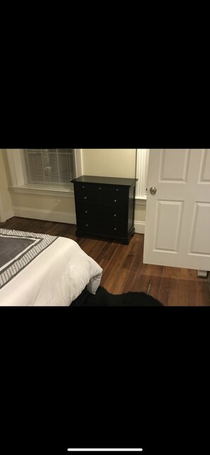 Comfortable bedroom with a bed, dresser, and door.