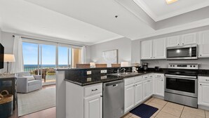 A modern kitchen with white cabinets, stainless steel appliances, and a large island.