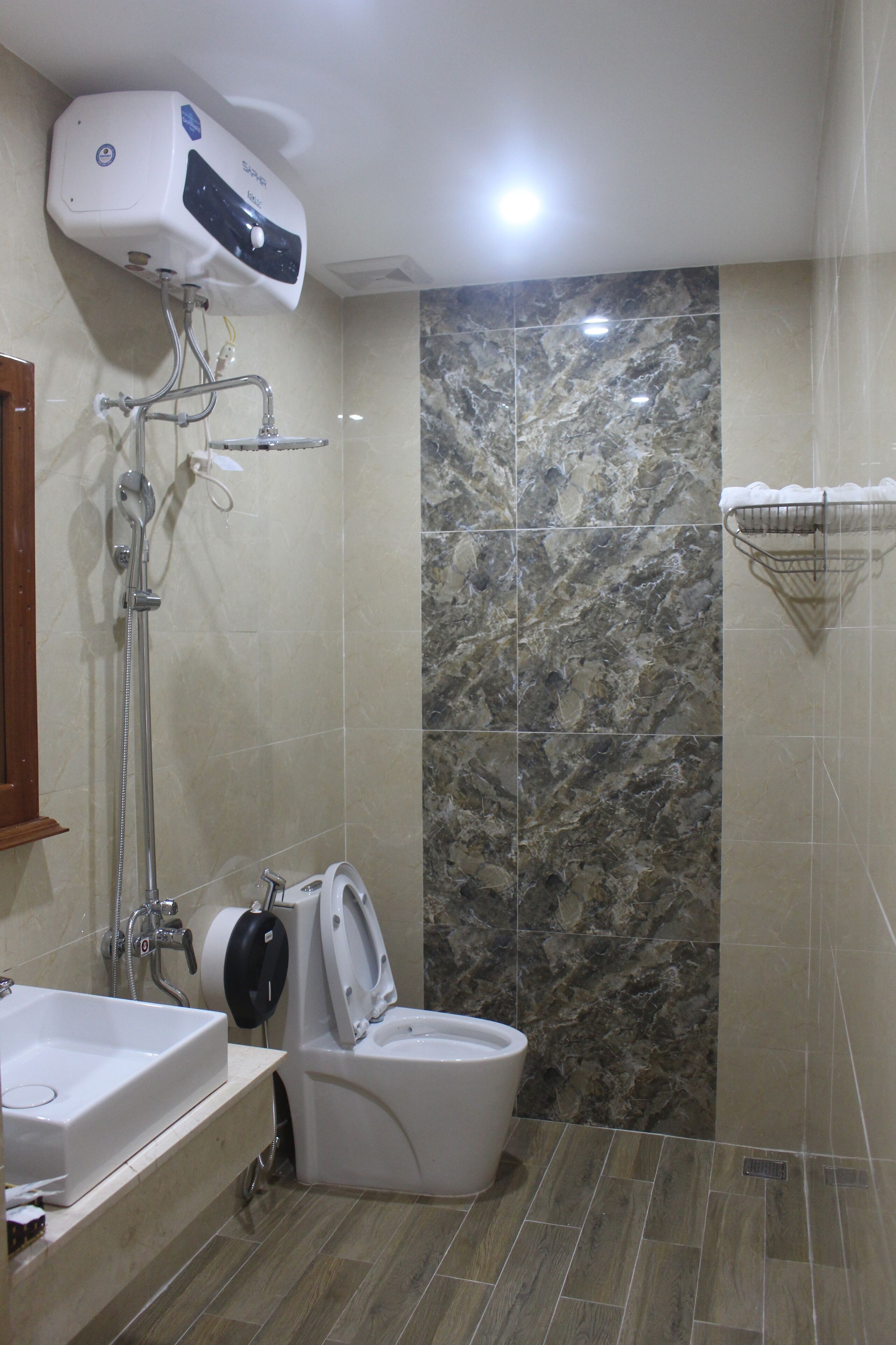 Een badkamer met een douche, toilet en wastafel.