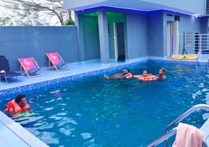 Ein Schwimmbecken mit Liegestühlen und einem Rettungsschwimmer.