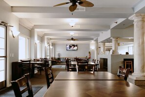 Enjoy meals in this elegant dining area with a long table, comfortable chairs, and a fireplace.