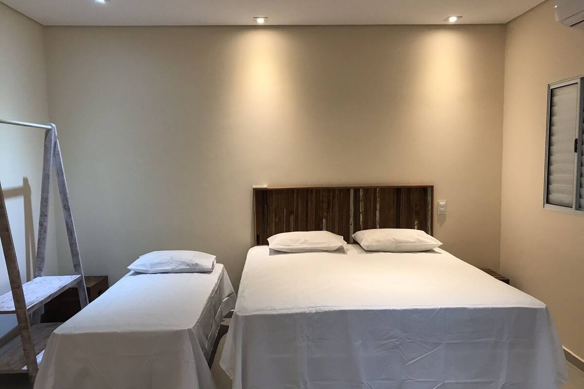 Ein Hotelzimmer mit zwei Einzelbetten, einem Holzkopfende und einem kleinen Tisch mit weißem Tuch.