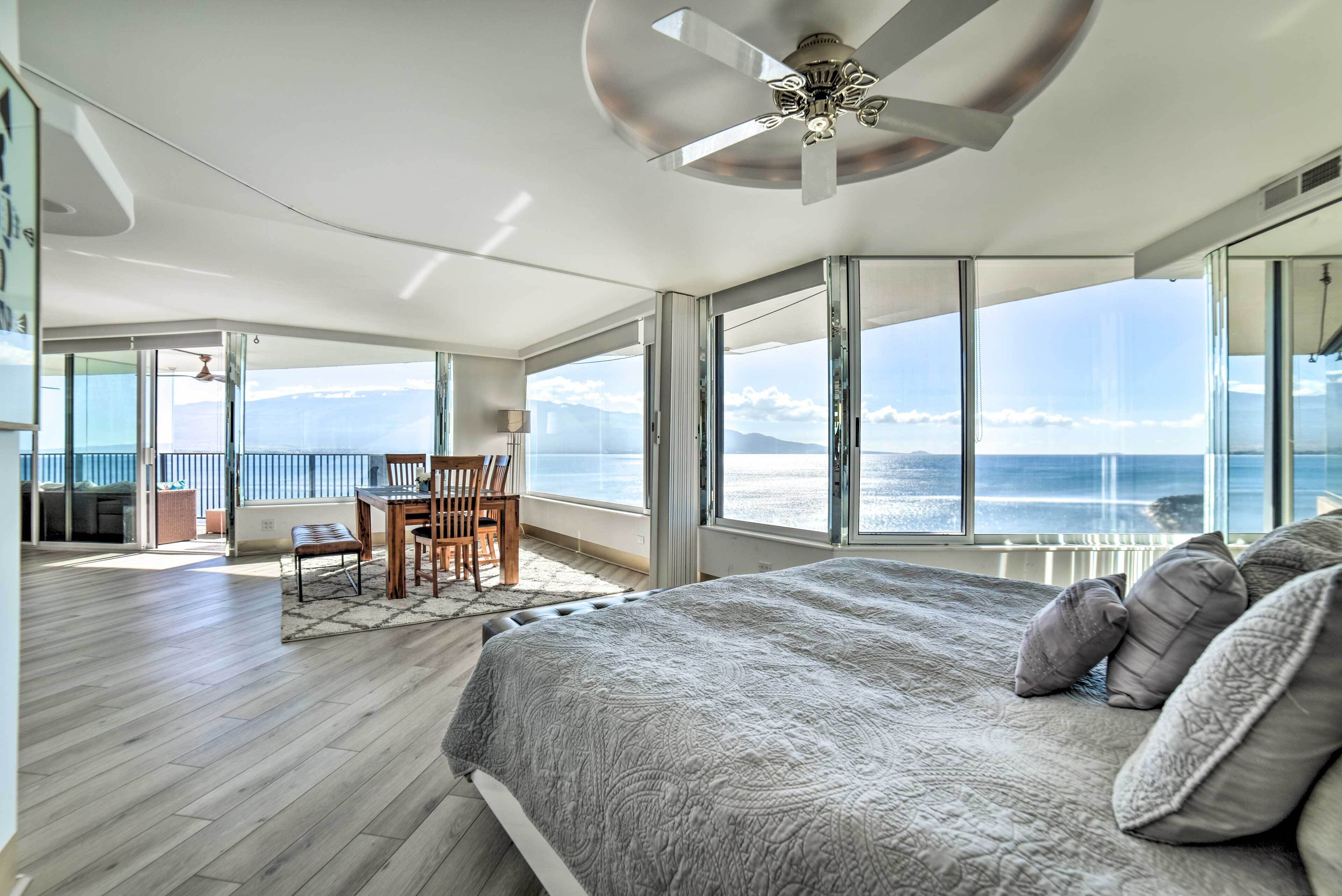 Una camera da letto con un letto grande, un ventilatore a soffitto e vista sull'oceano.