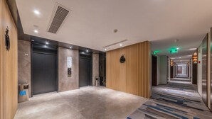 A modern hotel lobby with a marble floor, wooden paneling, and a patterned carpet. - Holiday Inn Express Ningbo City Center by IHG (Ningbo)