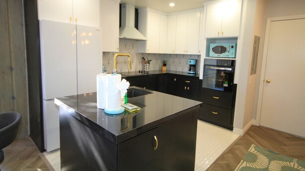 A modern kitchen with white cabinets, a black countertop, and a built-in oven. - Mammoth Ski & Racquet Club #51 - Pet Friendly (Mammoth Lakes)