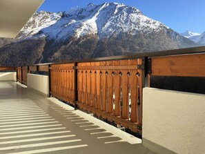 A corridor with a wooden fence and a view of snow-capped mountains. - Apartment Bijou by Interhome (Saas-Fee)