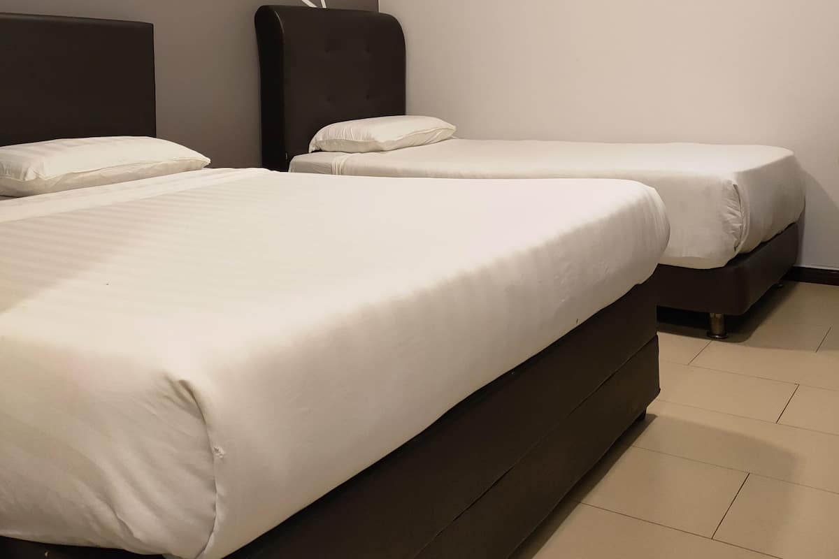 Et hotelværelse med to senge, et moderne vægdesign og en loftslampe.