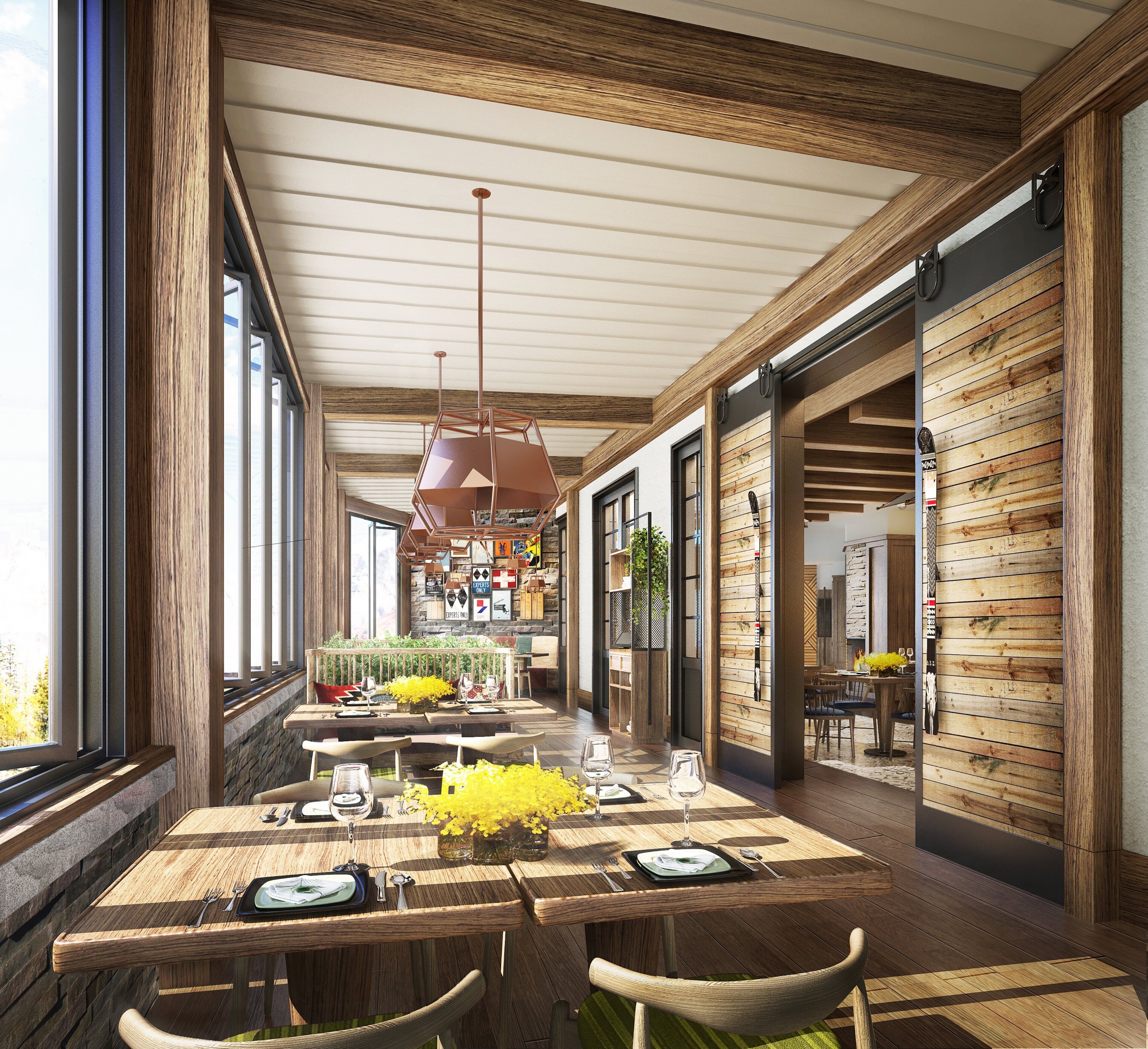 A spacious dining area with wooden tables and chairs, a central hanging light fixture, and a view through large windows.