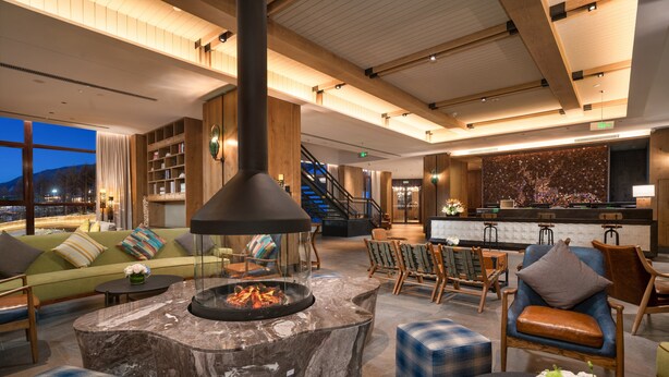 A spacious lobby with a fireplace, seating areas, and a staircase leading to upper floors. - Holiday Inn Jilin Beidahu by IHG (Jilin)