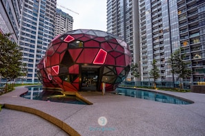 A modern spherical building with a geometric facade, surrounded by a pool and high-rise residential buildings. - Arte Plus KLCC by FavSpace (Kuala Lumpur)