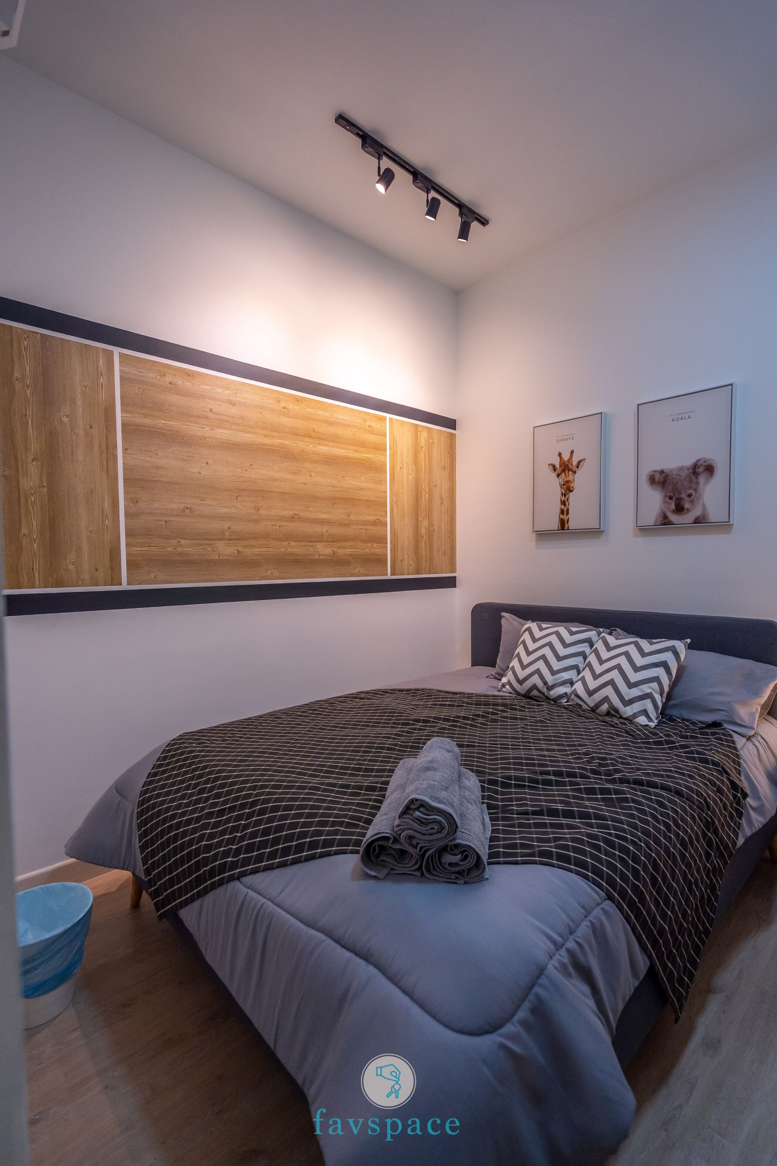 Un dormitorio moderno con una cama grande, una pared de acento de madera y dos cuadros con imágenes de animales.